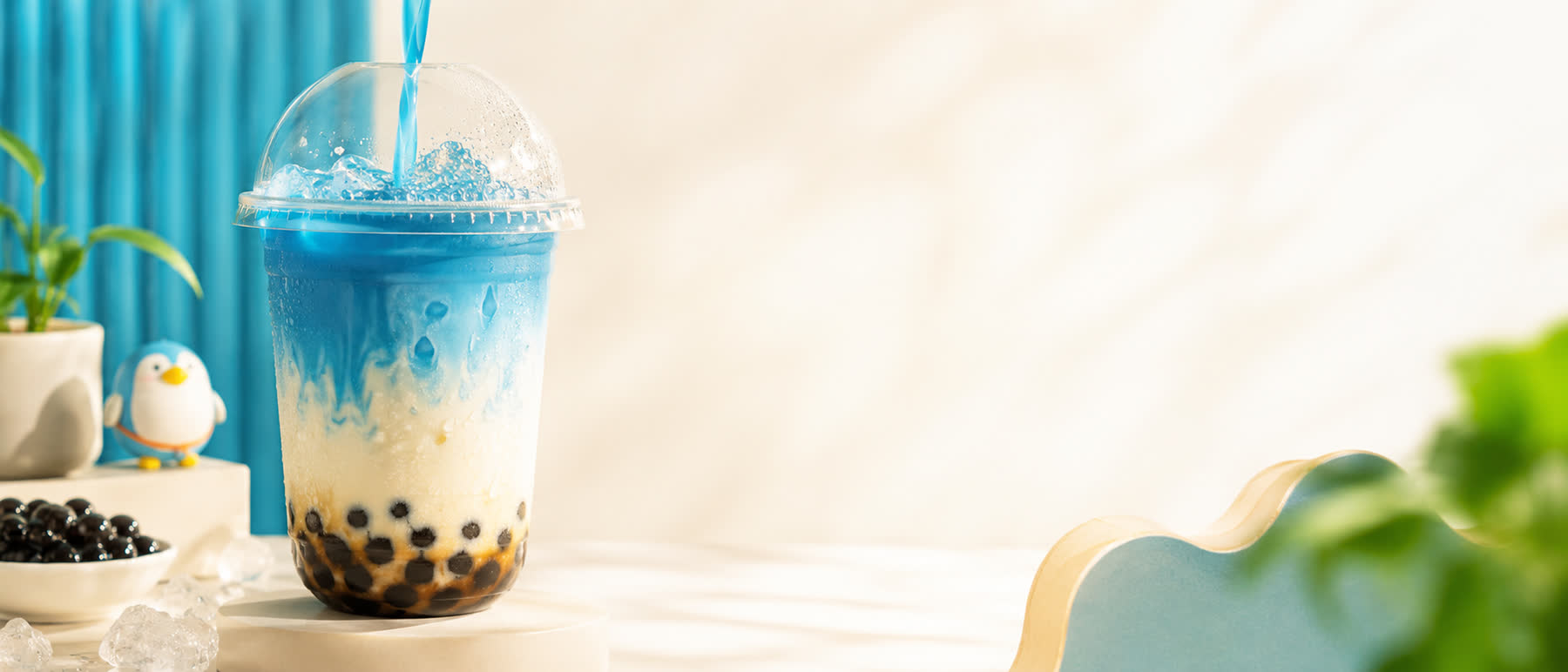 A blue butterfly-pea boba drink being poured over tapioca pearls at Bubble Tea Shop in Anytown